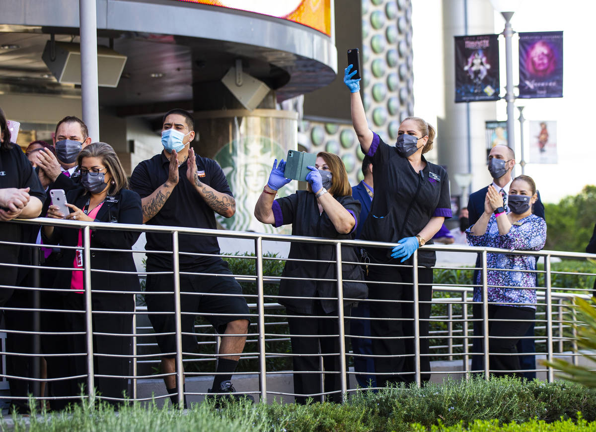 Employees watch as dancers perform to mark the reopening of the Planet Hollywood Resort in Las ...
