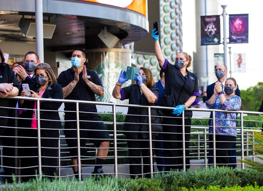 Employees watch as dancers perform to mark the reopening of the Planet Hollywood Resort in Las ...