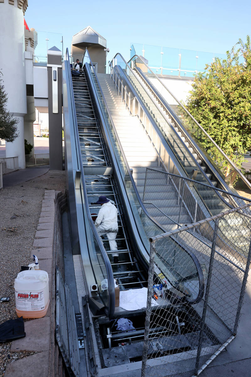 Workers perform scheduled maintenance on an escalator for the pedestrian bridge between Excalib ...