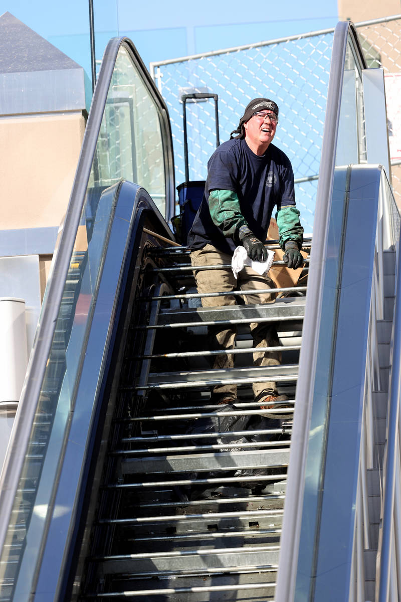 A worker who declined to give his name performs scheduled maintenance on an escalator for the p ...