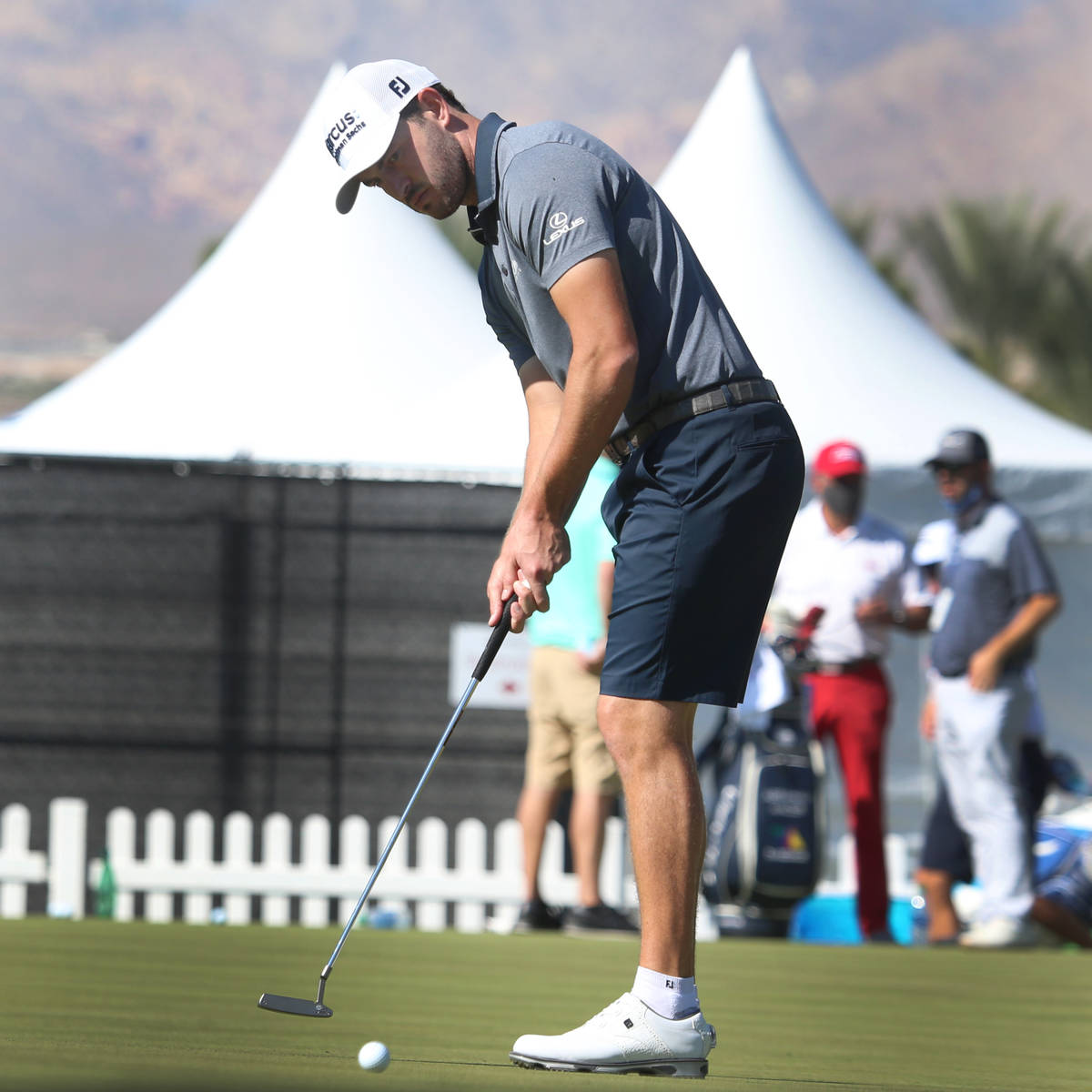 Patrick Cantlay, right, with his trainer Jamie Mulligan, putts the ball during the 2020 Shriner ...