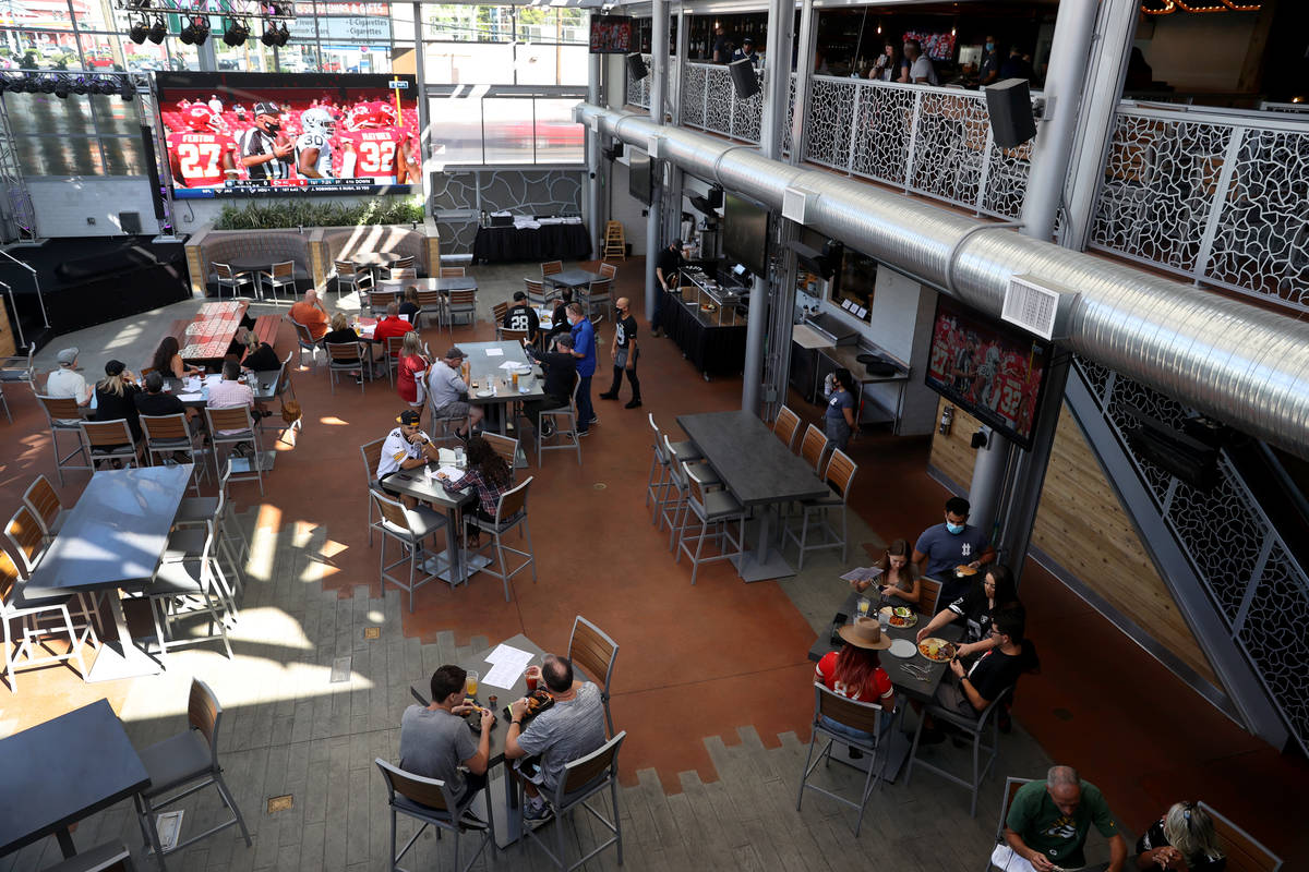 Fans watch a Raiders game on the 18-foot screen at The Front Yard at Ellis Island (Erik Verduzc ...