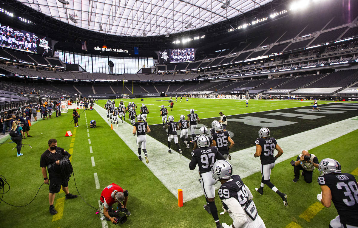 Las Vegas Raiders players run on to the field for the start of their home opening NFL game agai ...