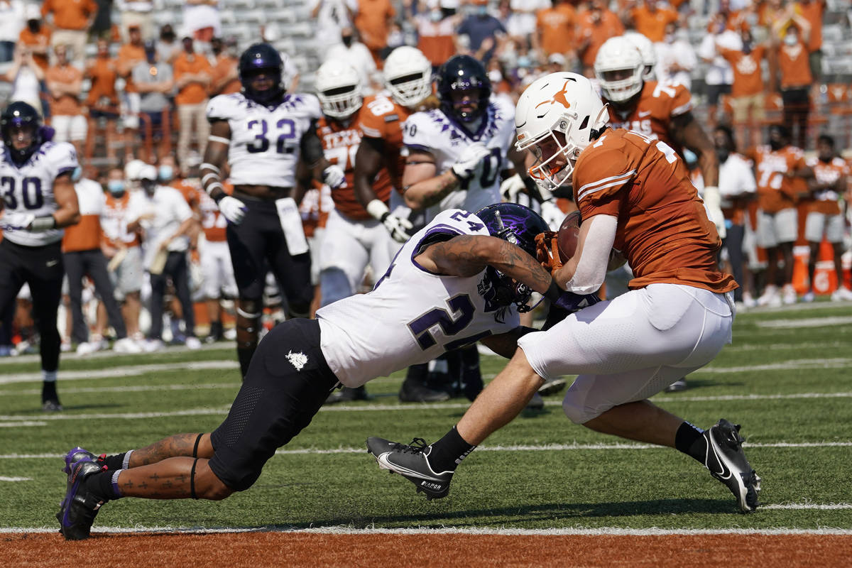 Texas wide receiver Jake Smith (7) is hit by TCU safety Ar'Darius Washington (24) as he makes a ...