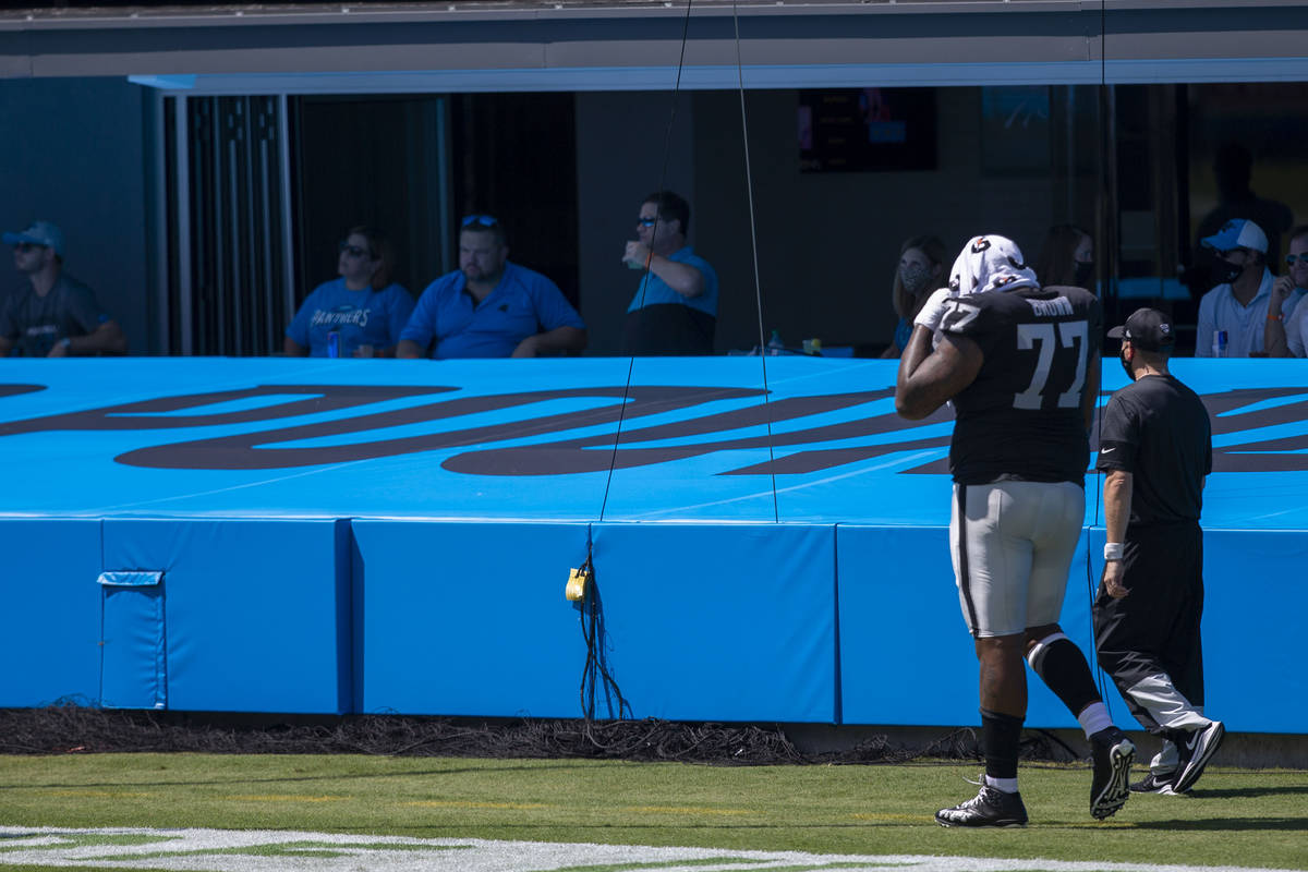 Las Vegas Raiders offensive tackle Trent Brown (77) walks off the field with a trainer after th ...