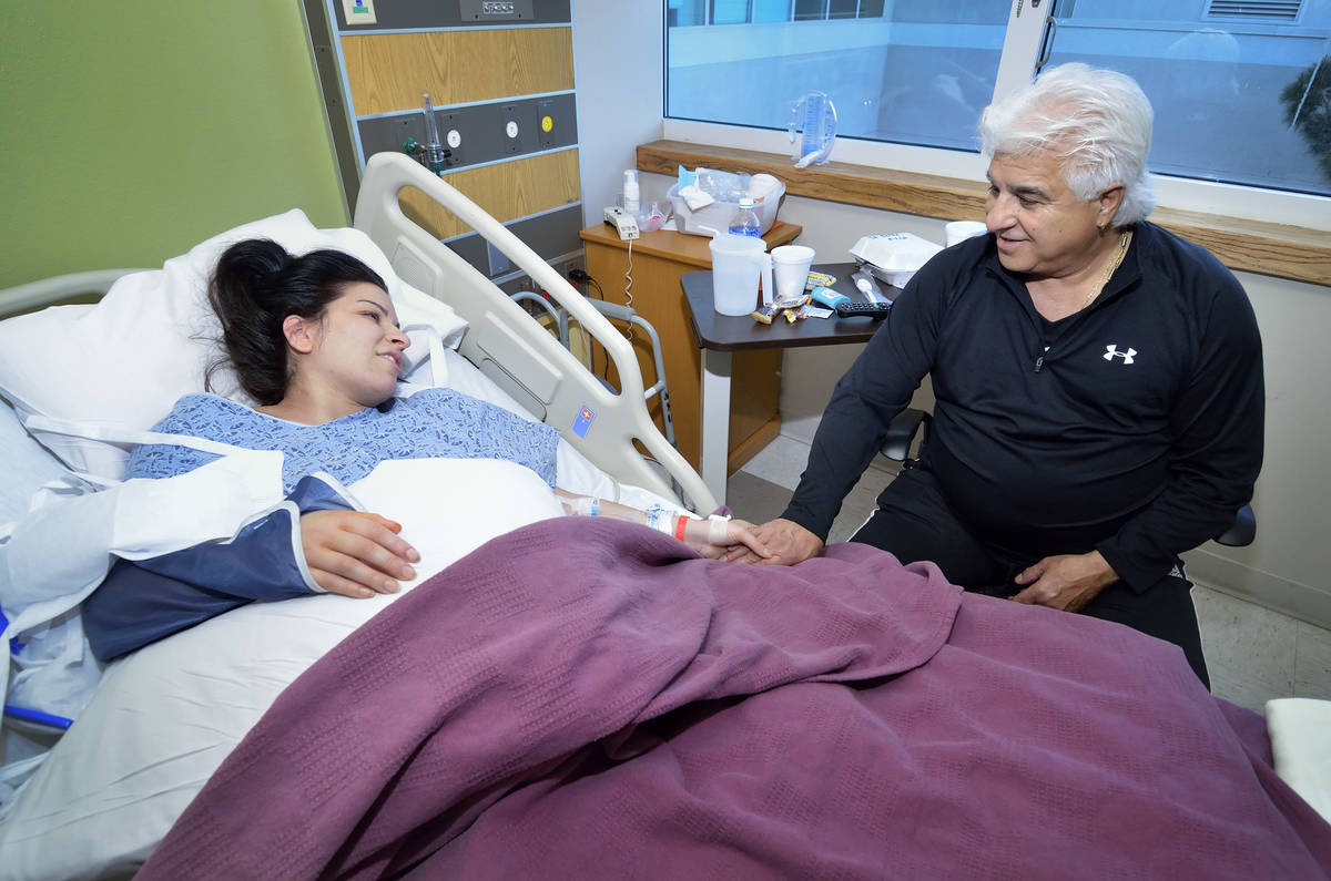 Michael Marotta, right, visits with his daughter Regina Marotta as she recovers from surgery to ...