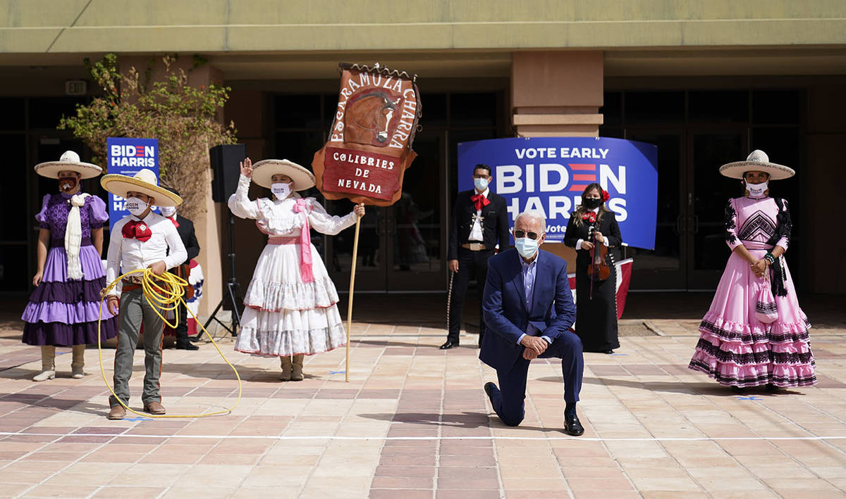 Democratic presidential candidate former Vice President Joe Biden takes a knee as he poses for ...