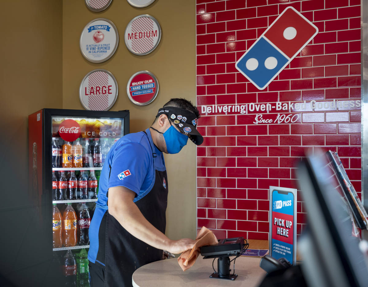 Domino's general manager Jessy Cortez sanitizes surfaces at the Domino's located off of East Wi ...