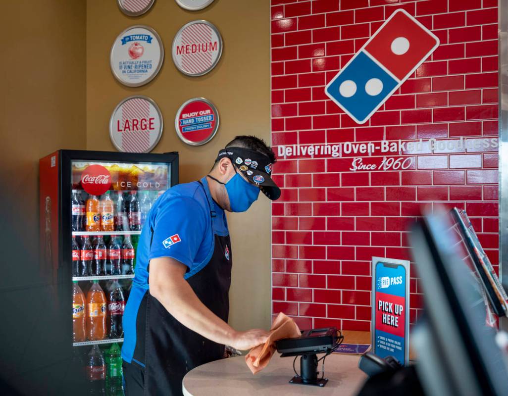 Domino's general manager Jessy Cortez sanitizes surfaces at the Domino's located off of East Wi ...