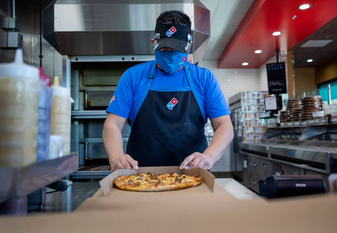 Domino's general manager Jessy Cortez boxes a pizza to be delivered at the Domino's located off ...