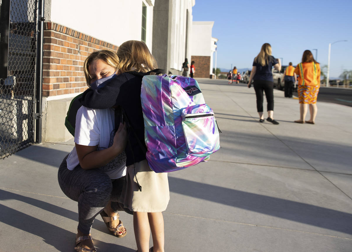 Connie Dunn hugs her daughter Anabell, 5, kindergarten student, after dropping her off at Legac ...