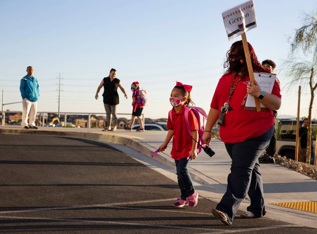 Lexi Parlade, 5, is accompanies by her kindergarten teacher, Deidre Gernon, as she arrives at L ...