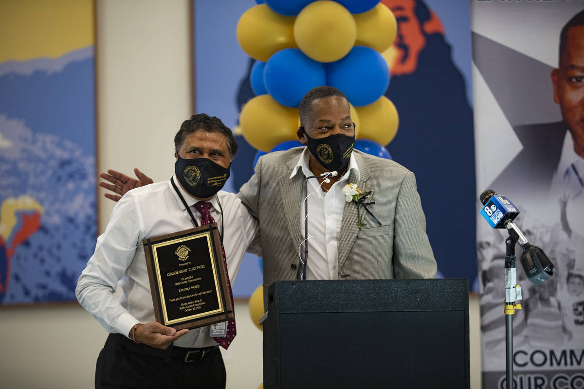 Clark County Commissioner Lawrence Weekly, right, gives Chandrakant Patel, left, the constructi ...