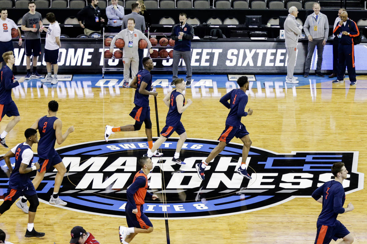 Syracuse players warm up during practice at the NCAA men's college basketball tournament, in Om ...