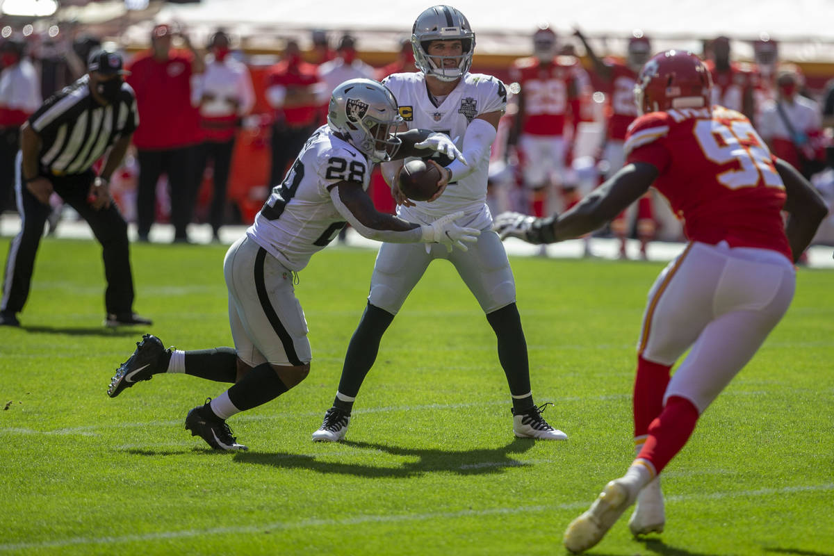 Las Vegas Raiders quarterback Derek Carr (4) hands off the football to running back Josh Jacobs ...