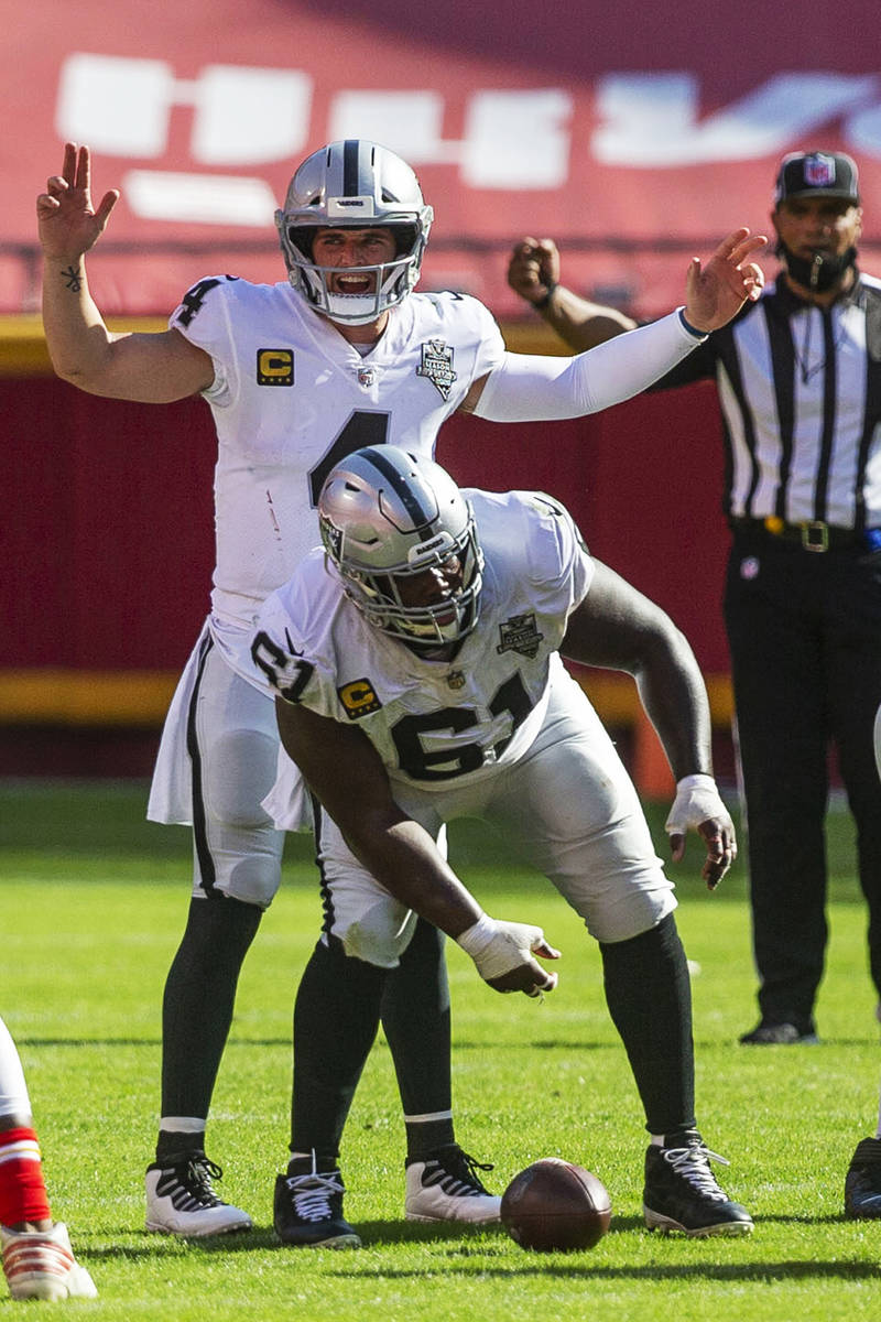 Las Vegas Raiders quarterback Derek Carr (4) calls a play at the line of scrimmage as center Ro ...