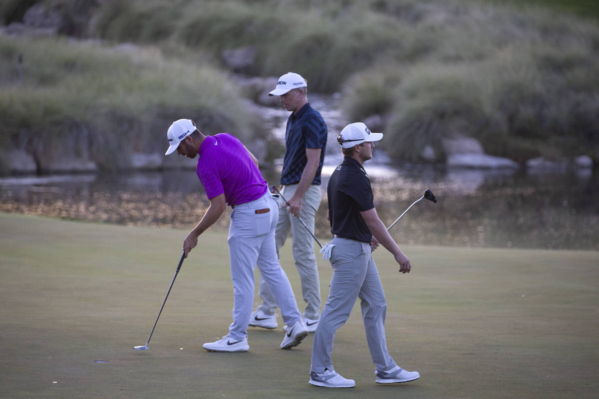 Matthew Wolff, left, Martin Laird, center, and Austin Cook, right, assess the putting green dur ...