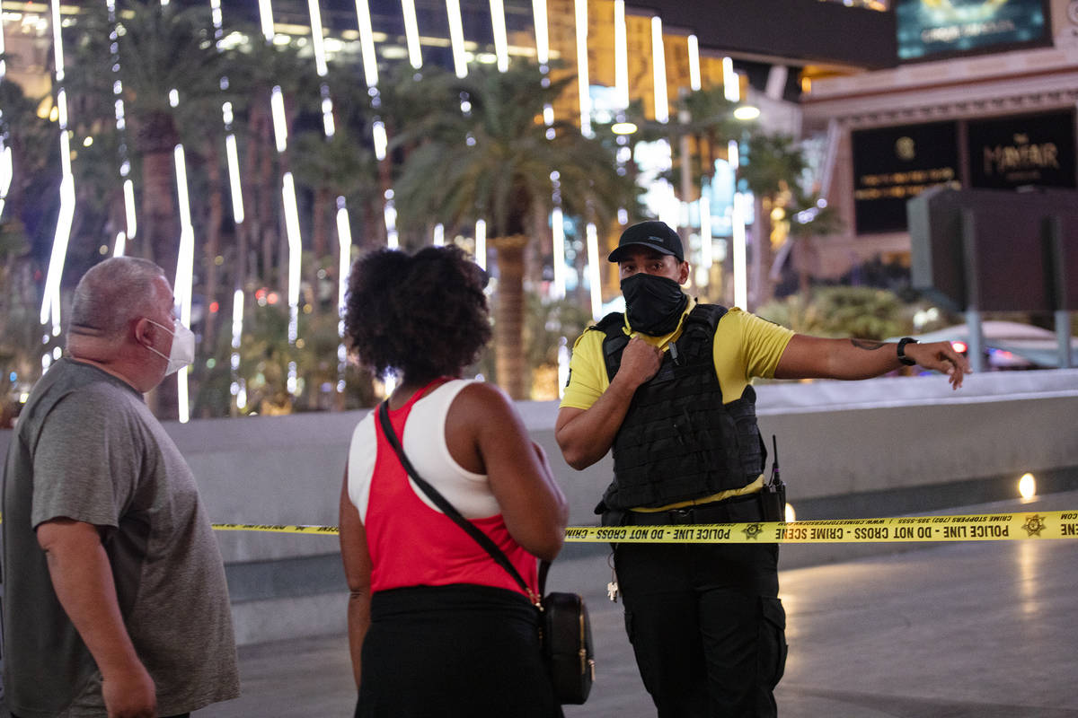 A security guard speaks with onlookers at the scene on the Strip where a man was shot at the Mi ...