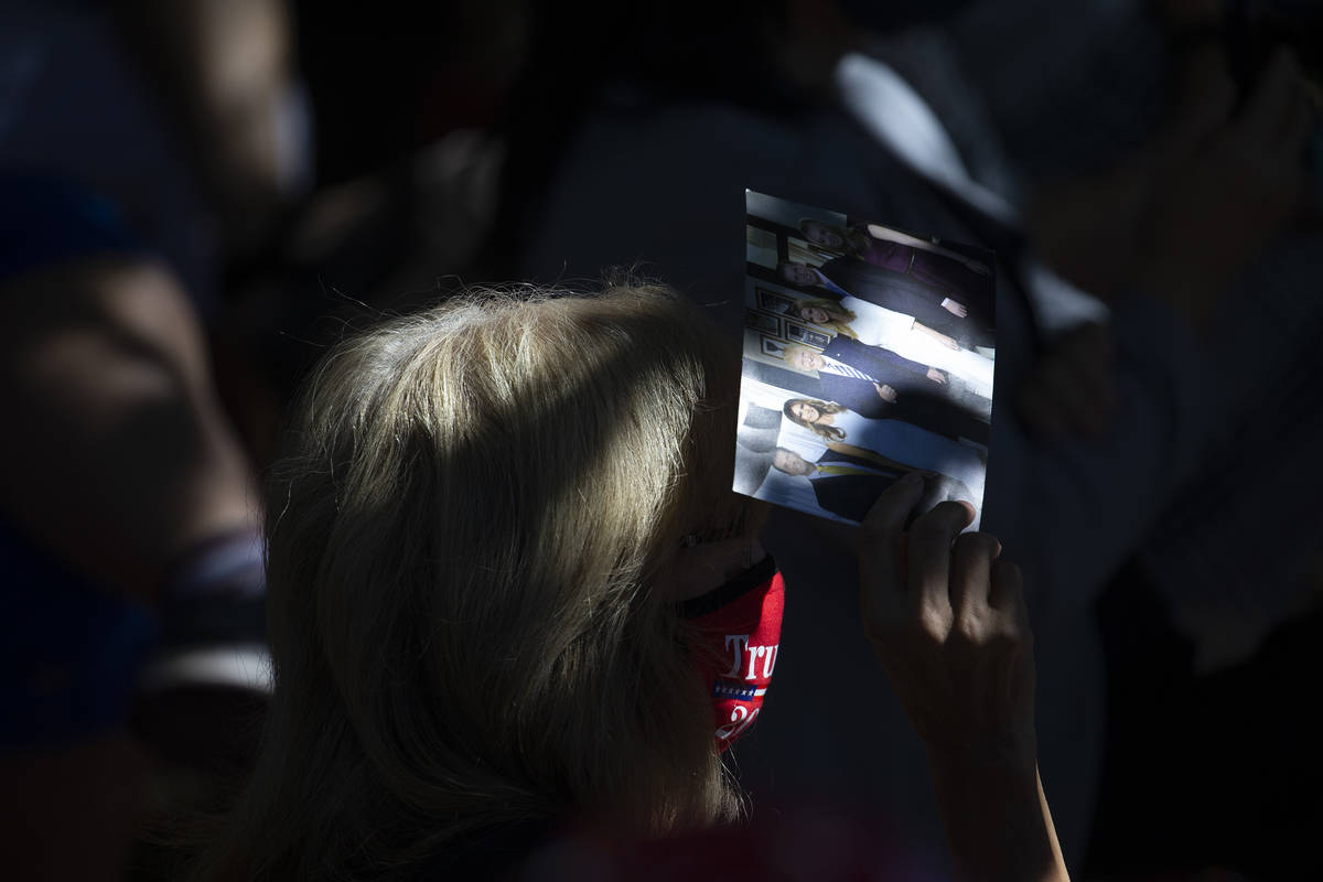 An audience member shades herself with a photo of the Trump family during an event featuring Iv ...
