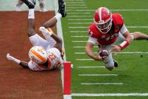 Georgia quarterback Stetson Bennett (13) dives past Tennessee defensive back Jaylen McCollough ...