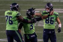 Seattle Seahawks quarterback Russell Wilson (3) is congratulated by teammates offensive lineman ...