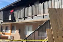 A maintenance worker at Corona Del Sol Apartments cleans up debris after a fatal fire in the ea ...