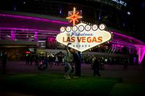 Pep rally attendees take photos with a scale model of the Las Vegas sign on Toshiba Plaza outsi ...