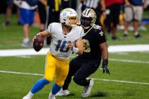 Los Angeles Chargers quarterback Justin Herbert (10) scrambles under pressure fromNew Orleans S ...