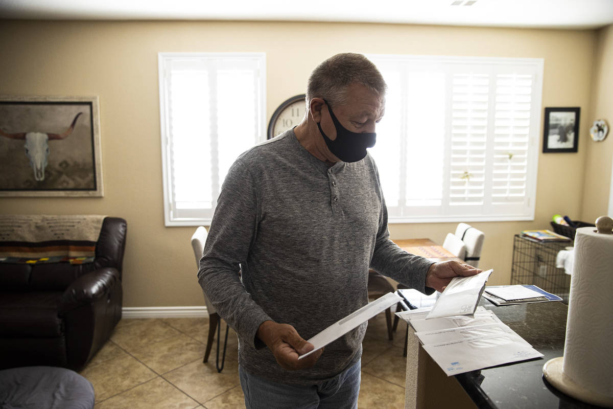 Graeme Lovatt shows some of the many letters from the Nevada Department of Employment, Training ...