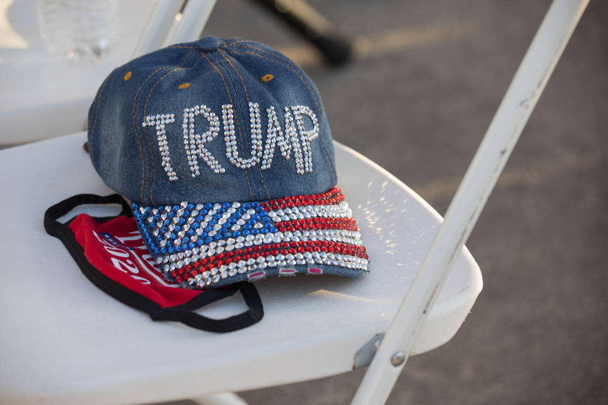 A hat and face mask acts as a seat holder at a campaign event for President Trump on Wednesday ...