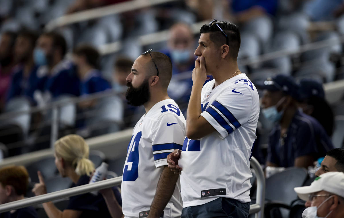 Dallas Cowboys fans look on as Dallas Cowboys quarterback Dak Prescott is carted off the field ...