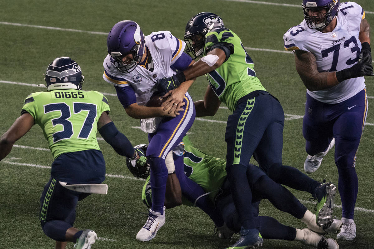 Minnesota Vikings quarterback Kirk Cousins is tackled by Seattle Seahawks defensive back Quandr ...