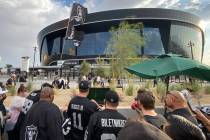 Las Vegas Raiders fans huddled around a 20-inch television on the north end of Allegiant Stadiu ...