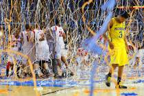 In this April 8, 2013, file photo, Michigan guard Trey Burke (3) walks off the court as confett ...