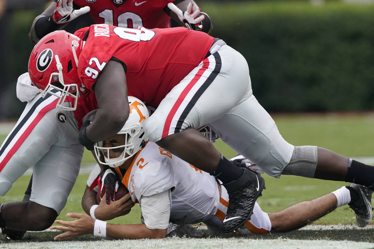 Tennessee quarterback Jarrett Guarantano (2) is brought down by Georgia defensive lineman Julia ...