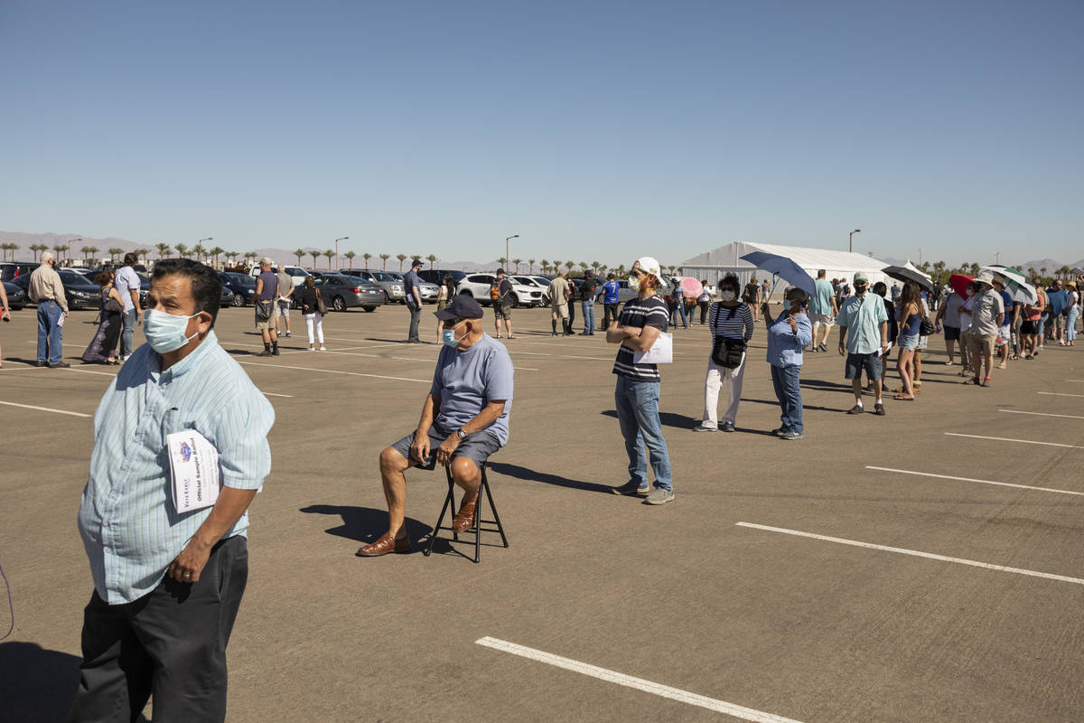 Individuals stand in line to early vote at the event tent located at Downtown Summerlin Las Veg ...