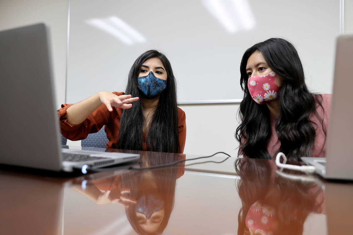 Karen Gutierrez, left, trains fellow UNLV student Leanne Villanueva on the school's COVID-19 co ...