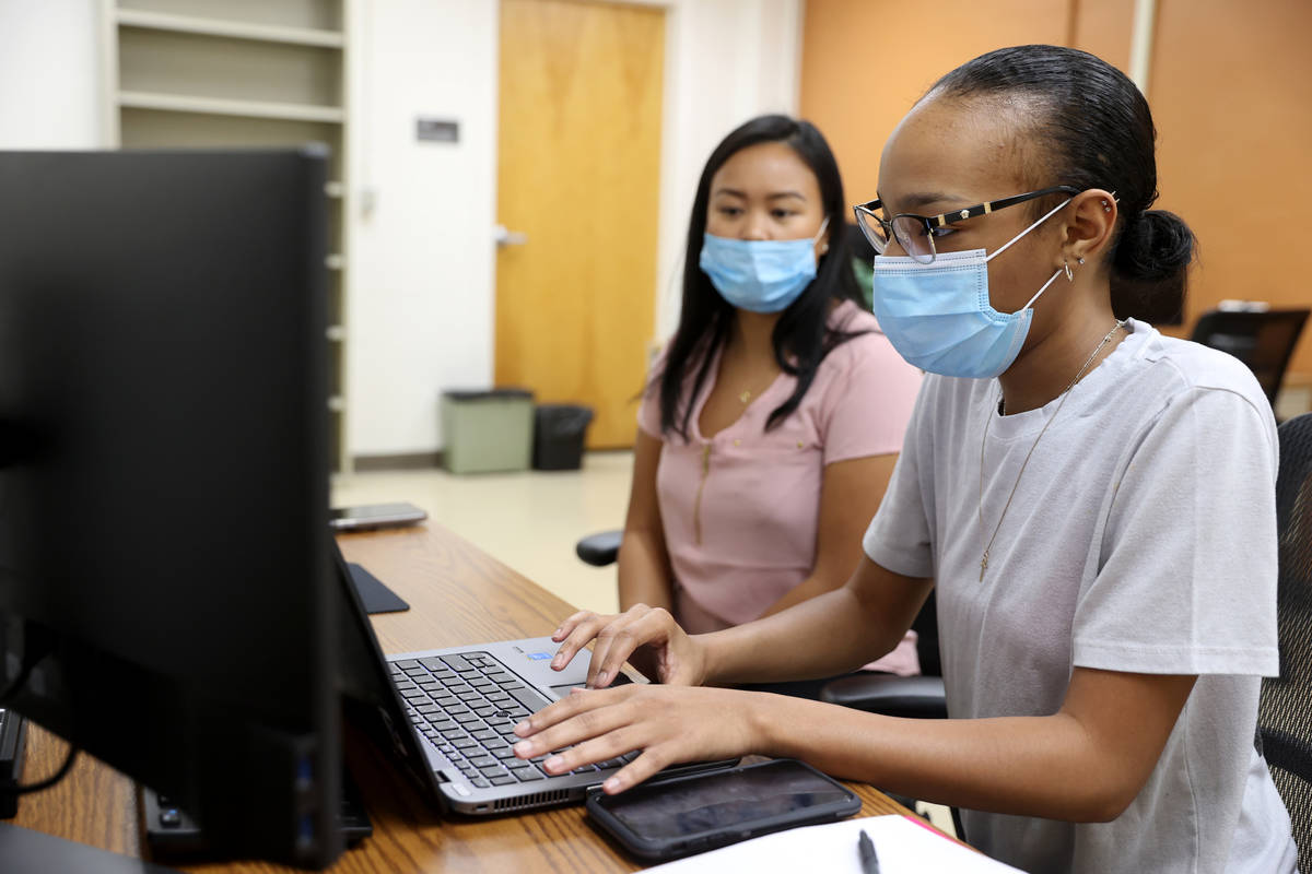 April Cruda, left, trains fellow UNLV student Alliyah Jackson on the school's COVID-19 contact ...