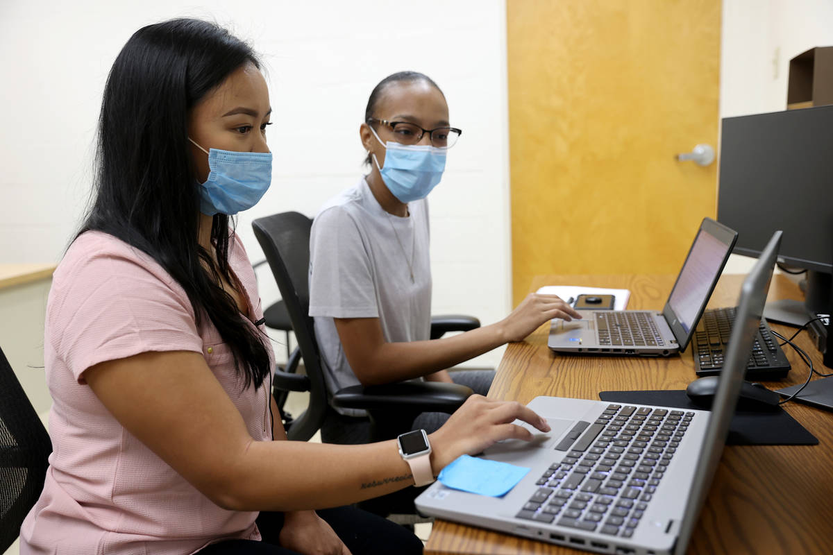 April Cruda, left, trains fellow UNLV student Alliyah Jackson on the school's COVID-19 contact ...