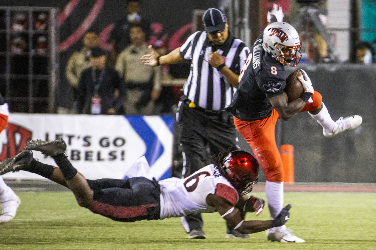 UNLV Rebels running back Charles Williams (8, right) attempts to escape a tackle attempt by San ...