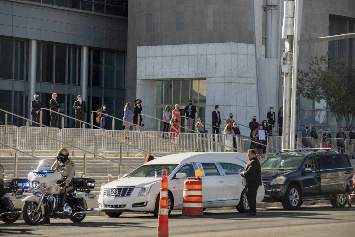 A police-escorted motorcade arrives at the front of the Lloyd D. George Federal Courthouse to h ...