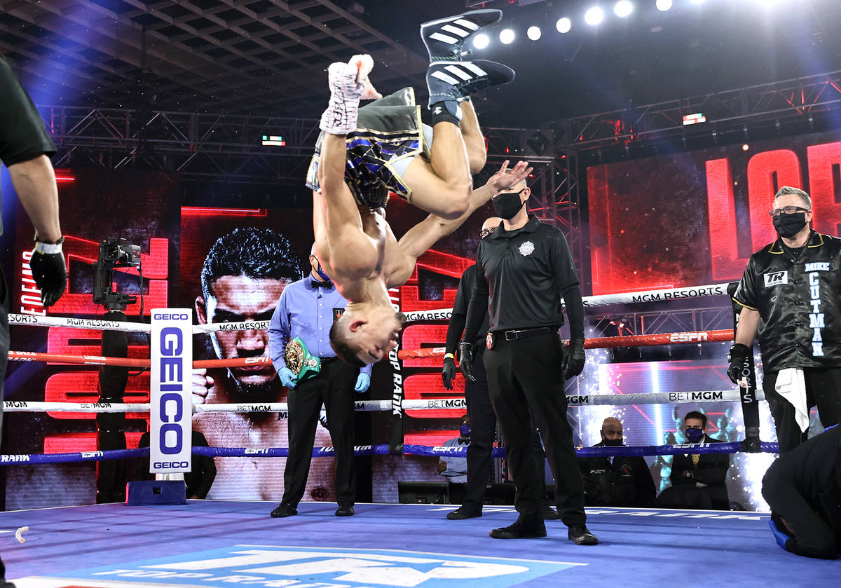 Teofimo Lopez does a flip after winning a unanimous decision over Vasiliy Lomachenko in their l ...
