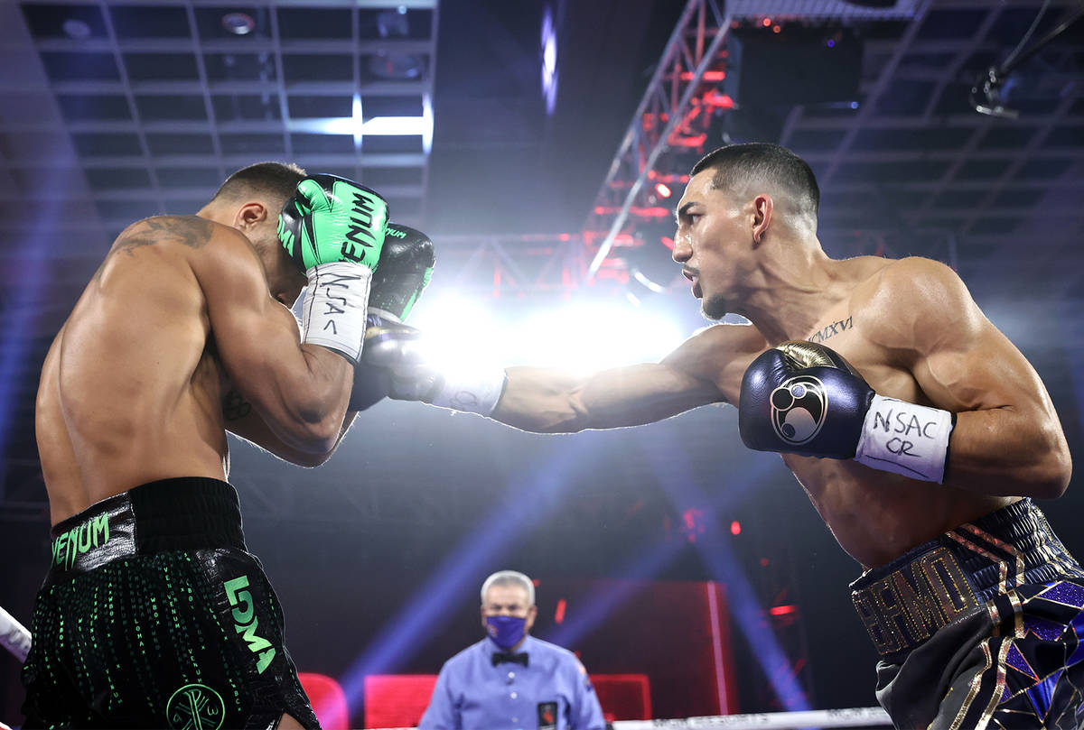 Teofimo Lopez, right, lands a punch against Vasiliy Lomachenko during their lightweight title f ...