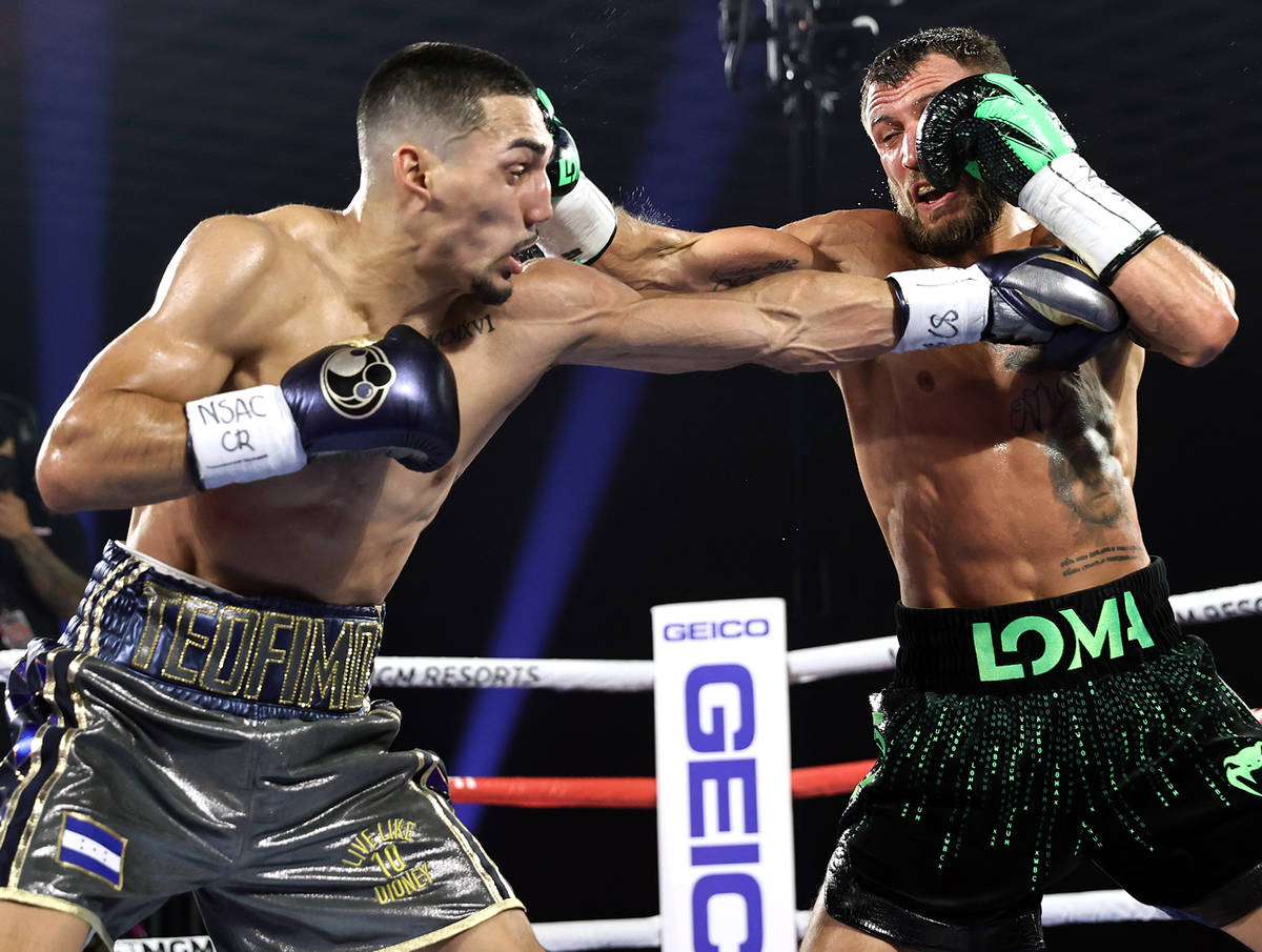Teofimo Lopez, left, and Vasiliy Lomachenko trade punches during their lightweight title fight ...