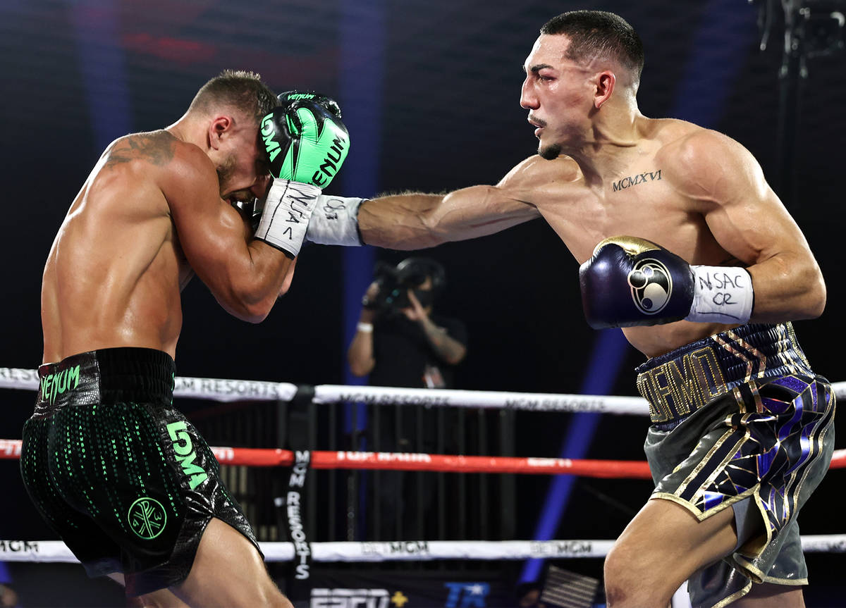 Teofimo Lopez, right, lands a punch against Vasiliy Lomachenko during their lightweight title f ...