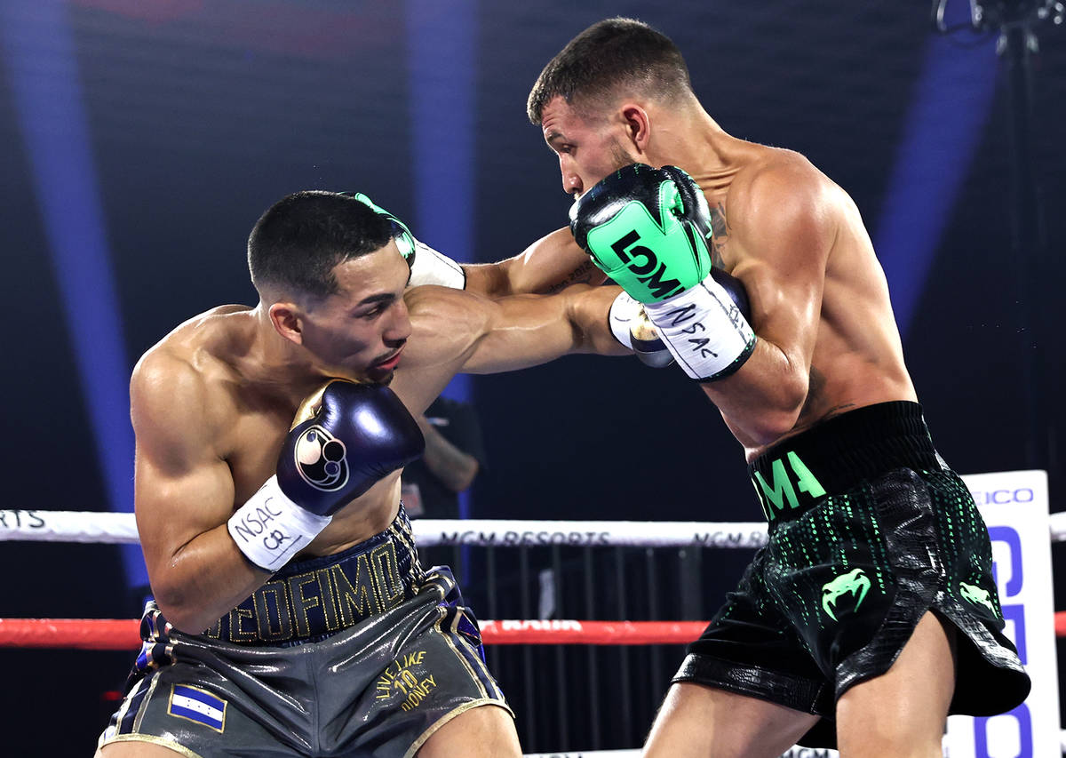 Teofimo Lopez, left, and Vasiliy Lomachenko trade punches during their lightweight title fight ...