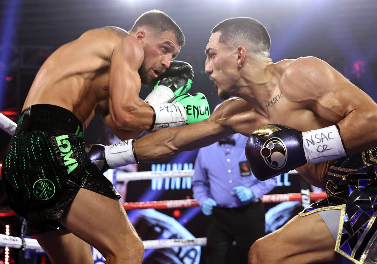 Teofimo Lopez, right, lands a punch against Vasiliy Lomachenko during their lightweight title f ...