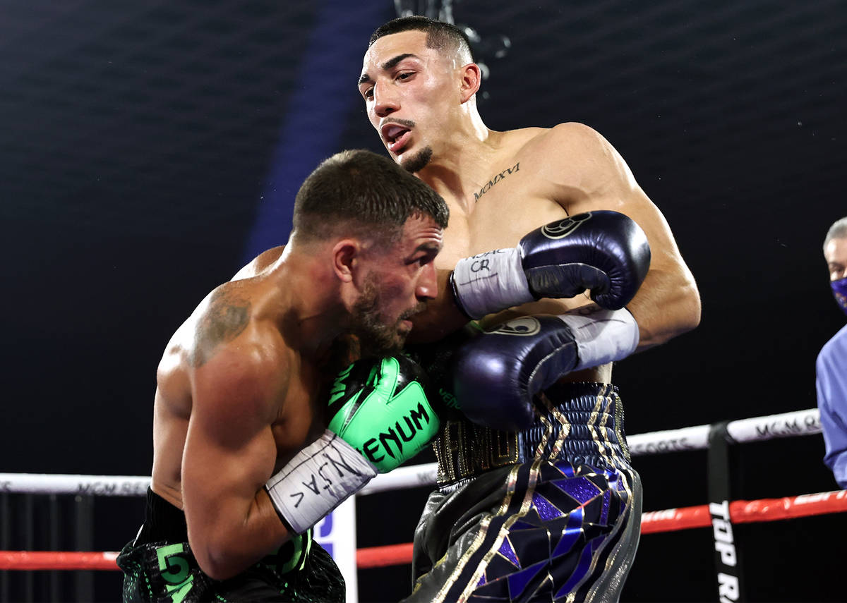 Vasiliy Lomachenko, left, lands a punch against Teofimo Lopez during their lightweight title fi ...