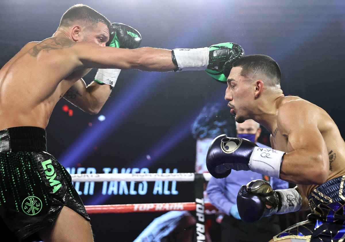 Vasiliy Lomachenko, left, lands a punch against Teofimo Lopez during their lightweight title fi ...