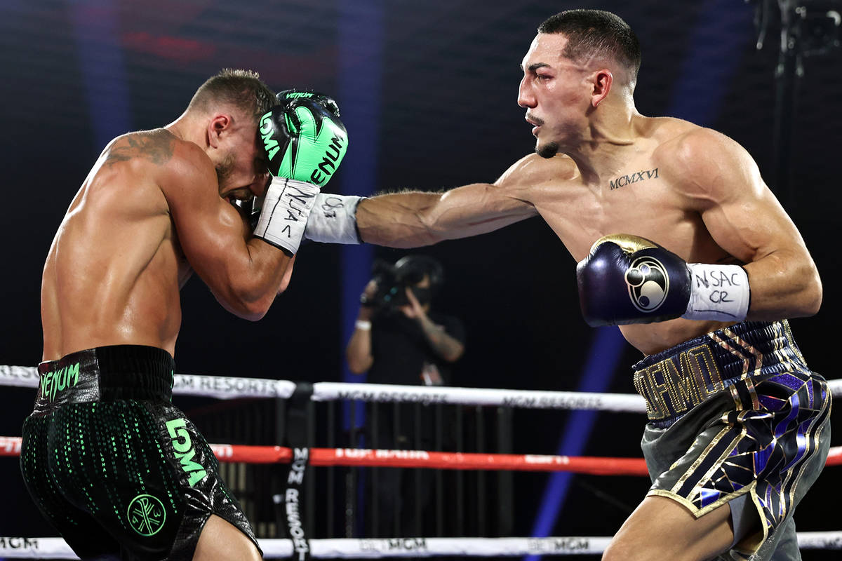 Teofimo Lopez, right, lands a punch against Vasiliy Lomachenko during their lightweight title f ...